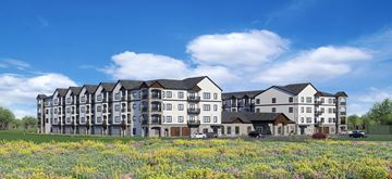 Alexandria apartment for rent - A large, modern apartment building with a grassy field in front.