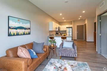 Cambridge townhouse for rent - A living room with a brown couch and a painting of a landscape on the wall.