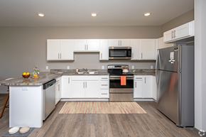 Cambridge townhouse for rent - A modern kitchen with white cabinets and stainless steel appliances.