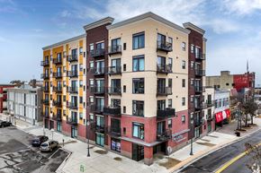 St Cloud apartment for rent - a city street with an apartment building with different colors and balconies