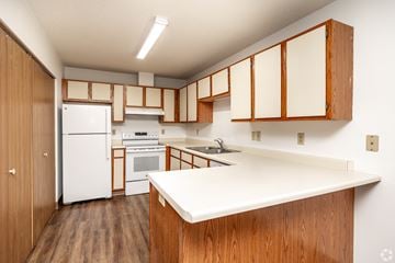 Mason City apartment for rent - A kitchen with wooden cabinets and a white counter.