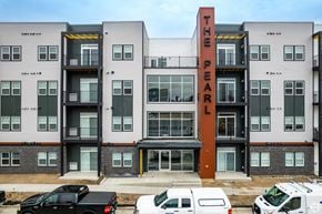 Owatonna apartment for rent - The Pearl apartment building with cars parked in front.
