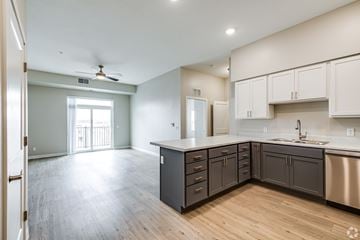 Owatonna apartment for rent - A kitchen with a stainless steel dishwasher and a fan on the ceiling.