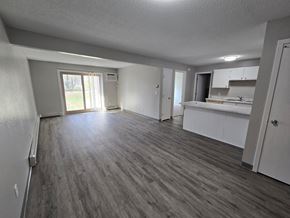 St Cloud apartment for rent - A spacious room with wooden flooring and white walls.