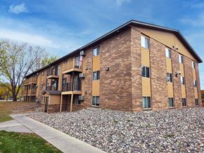 St Cloud apartment for rent - A large brick building with a grassy area in front.