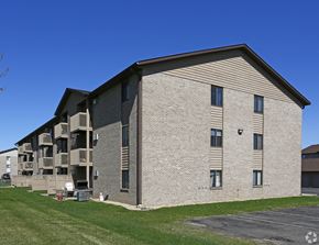 Albertville apartment for rent - A large apartment building with a parking lot in front.