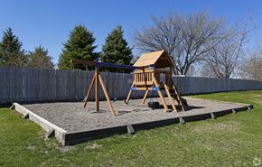 Albertville apartment for rent - A wooden swing set with a brown roof is situated on a gravel area in a backyard.