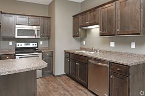 St Cloud apartment for rent - a kitchen with wooden cabinets and granite counter tops and stainless steel appliances
