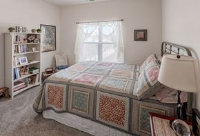 Hastings apartment for rent - a bedroom with a bed and a window and a book shelf