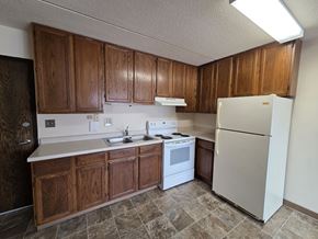 St Cloud apartment for rent - A kitchen with wooden cabinets and a white refrigerator.