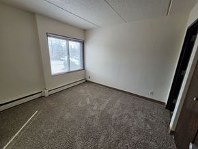 St Cloud apartment for rent - A room with a carpeted floor and a window with blinds.
