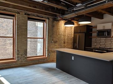 Milwaukee apartment for rent - A kitchen with a black counter and a brick wall.