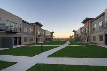  Row of modern townhouses with a walkway in the foreground