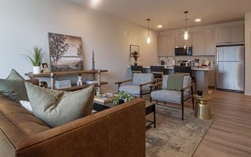 Pewaukee apartment for rent - A living room with a brown couch and a painting on the wall.