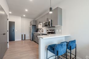Monona apartment for rent - A kitchen with a white counter and blue chairs.