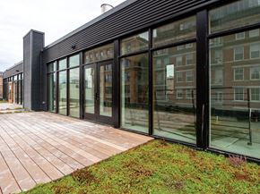 Milwaukee apartment for rent - A modern building with a glass facade and a brick walkway in front.