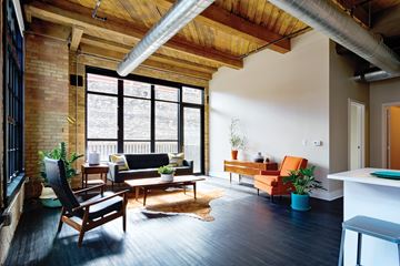 Milwaukee apartment for rent - A living room with a black couch and a wooden chair.