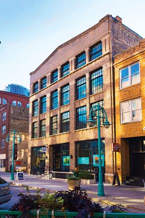Milwaukee apartment for rent - A street view of a building with a green light on the sidewalk.