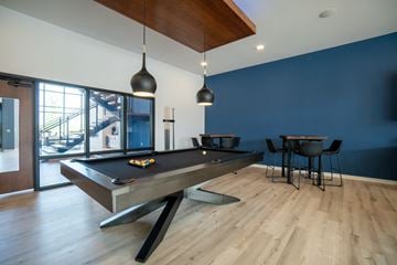 Madison apartment for rent - a pool table in a living room with blue walls and wood floors