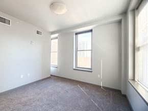 Kansas City apartment for rent - A sparsely furnished room with a window and a carpeted floor.