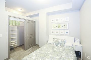 Kansas City apartment for rent - A bedroom with a bed, a nightstand, and a closet with a mirror.