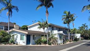 Costa Mesa apartment for rent - A row of houses with palm trees in front.