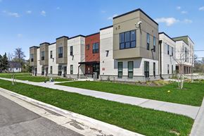 Detroit townhouse for rent - A row of modern townhouses with green lawns in front.