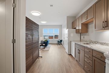 Boston apartment for rent - A modern kitchen with wooden cabinets and a marble countertop.