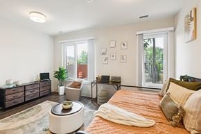Washington apartment for rent - A bedroom with a bed, a couch, a coffee table, and a window.