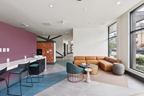 Washington apartment for rent - A modern office space with a pink wall and a variety of seating options.