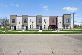 Detroit townhouse for rent - A row of modern townhouses with a parking lot in front.