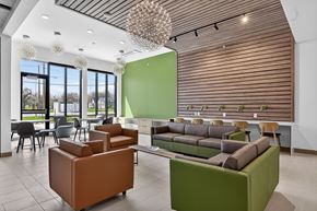 Detroit townhouse for rent - A modern living room with a green accent wall and a brown and green sofa.
