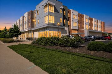 Cincinnati apartment for rent - A modern apartment building with a parking lot in front.