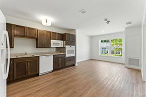 Stow apartment for rent - A kitchen with brown cabinets and white appliances.