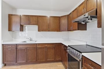 Northampton apartment for rent - A kitchen with brown cabinets and a white counter.