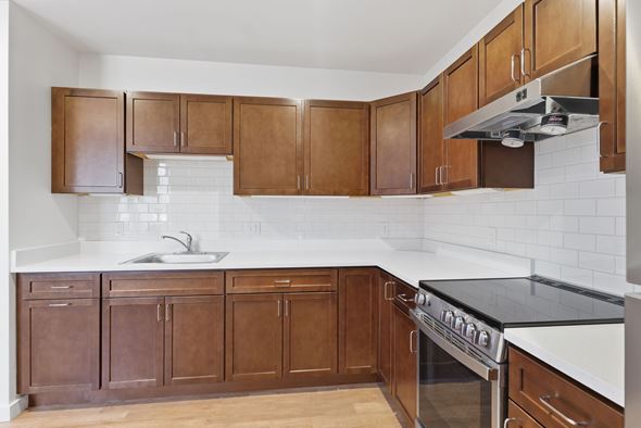 Northampton apartment for rent - A kitchen with brown cabinets and a white counter.