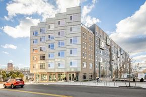 Boston apartment for rent - an apartment building on a city street with a red car