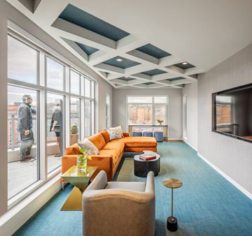 Boston apartment for rent - a living room with a orange couch and a television