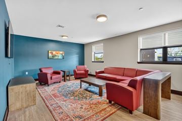 New Brunswick apartment for rent - A living room with red chairs and a red couch.