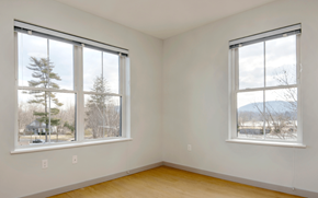 Northampton apartment for rent - Two windows in a room with wooden floors and white walls.