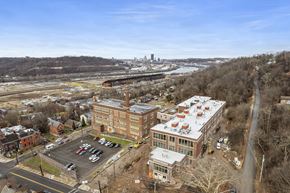 Pittsburgh apartment for rent - an aerial view of a city with buildings and a river