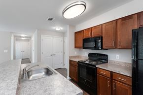 Baltimore apartment for rent - A kitchen with black appliances and brown cabinets.