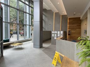 Bronx apartment for rent - A yellow caution sign is in front of a grey reception desk.