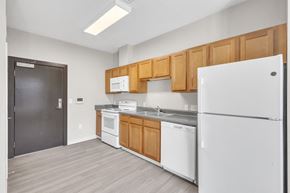 Cleveland apartment for rent - a kitchen with white appliances and wooden cabinets and a refrigerator