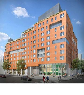 Bronx apartment for rent - A modern orange building with a green roof and a glass facade.