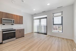 Chicago apartment for rent - A spacious kitchen with wooden cabinets and a microwave above the stove.