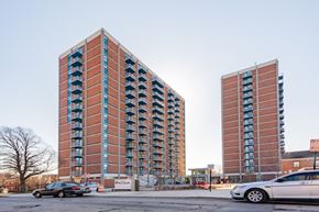 Baltimore apartment for rent - Two red brick buildings with balconies in front of a clear sky.