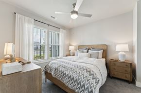 Fort Myers apartment for rent - A bedroom with a large bed, a ceiling fan, and a window with blinds at The Hendry Apartments, Fort Myers, FL, 33905