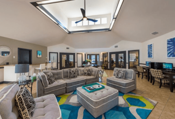 Panama City apartment for rent - A living room with a grey couch and a blue rug.