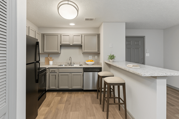 Smyrna apartment for rent - A kitchen with a black refrigerator and wooden floors.